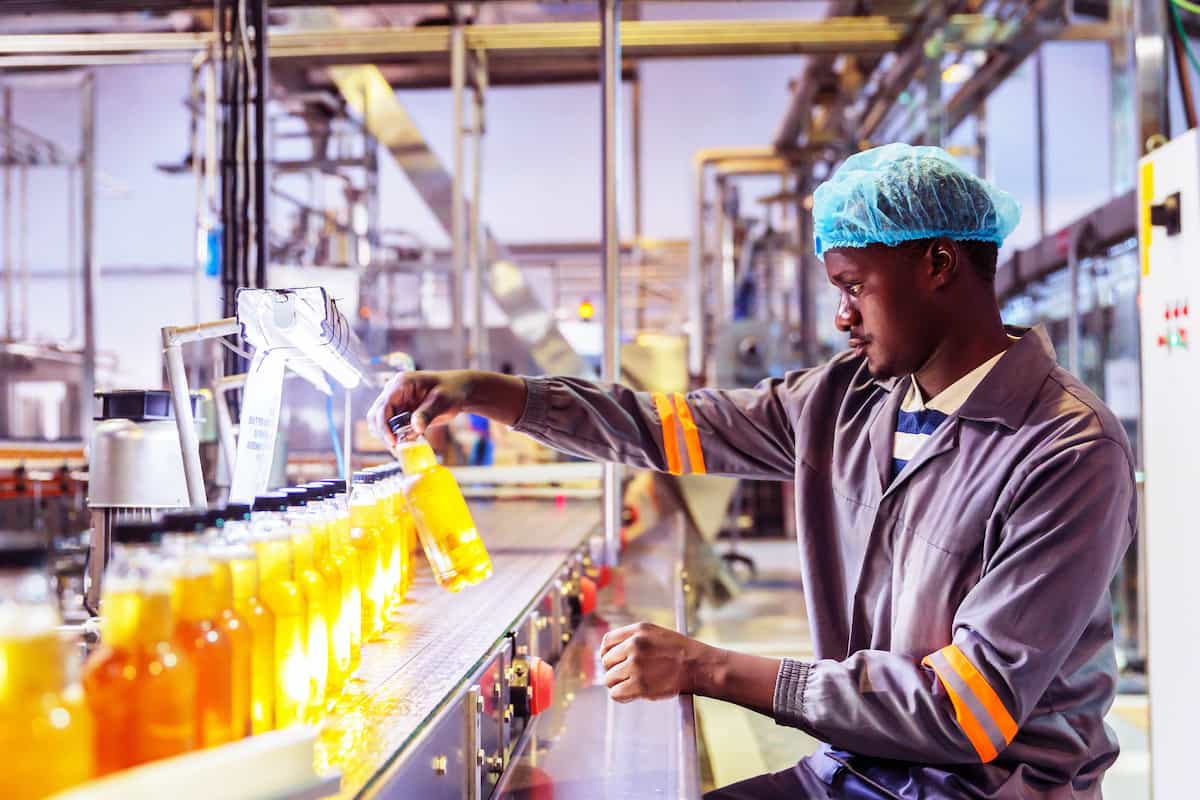 a worker reviews bottled product for quality assurance in an industrial facility